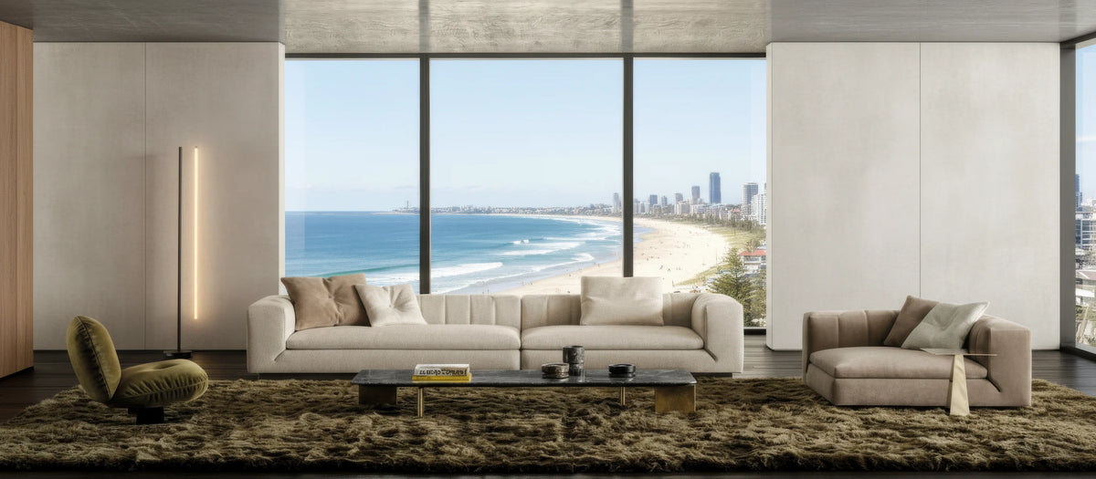 A light-filled living room overlooking the Australian coast, with a sculptural sofa and armchair